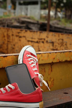 Red shoes with smart phone on yellow backgroundの写真素材