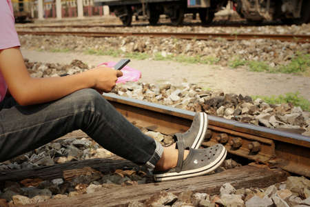 Women are using a phone at train stationの写真素材