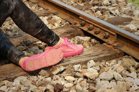 Woman wearing pink shoes at train station.の写真素材