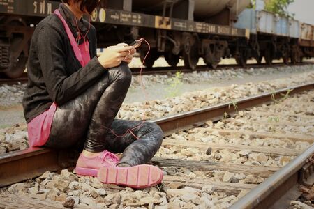 Women are using a phone at train stationの写真素材