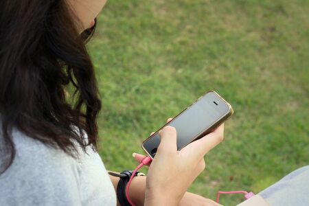 Women are using a phone at the parkの写真素材