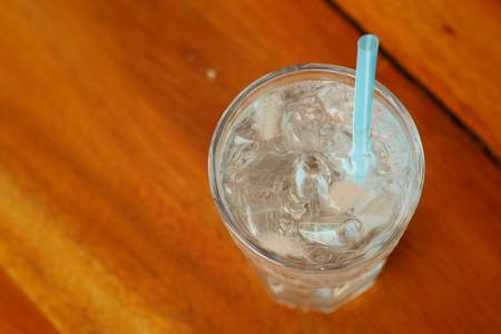Water in a glass on a background of brown wood.の写真素材