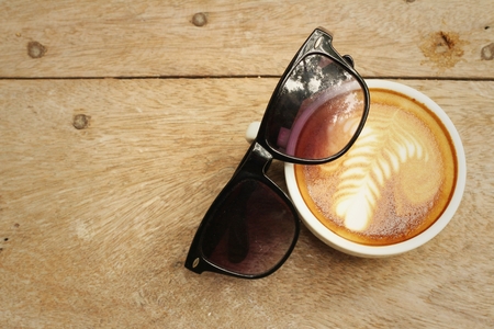 Coffee with sun glasses on background of wooden.の写真素材