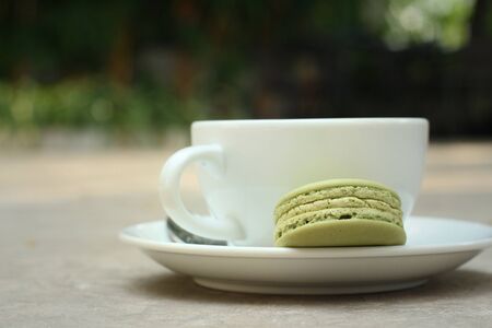 Hot green tea with macaroons at coffee shop.の写真素材