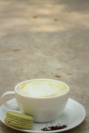 Hot green tea with macaroons at coffee shop.の写真素材
