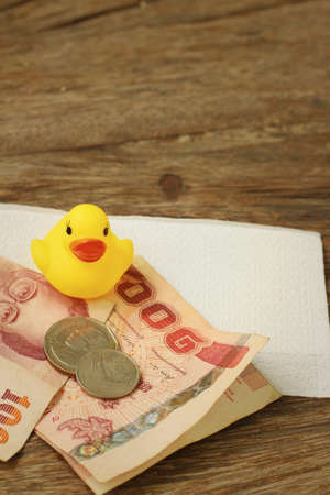 Yellow rubber duck with money of Thai Bath.の写真素材