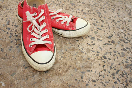 Red shoes on the floor of cement.