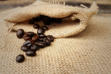 Coffee beans on background of brown fabricの写真素材