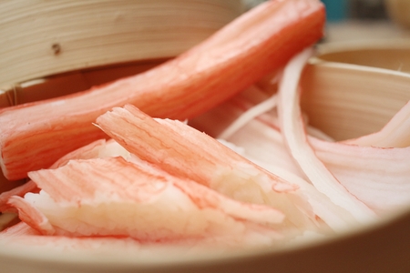 Crab stick in bowl on brown backgroundの写真素材