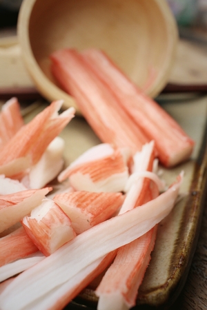 Crab stick in plate on brown backgroundの写真素材