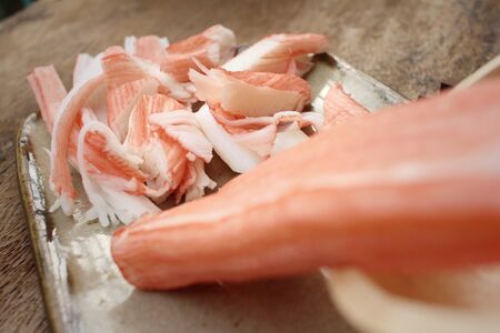 Crab stick in plate on brown backgroundの写真素材