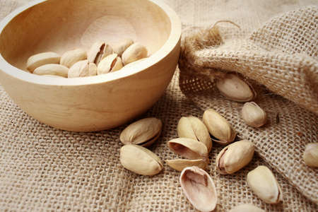 Pistachios nuts on a background of brownの写真素材