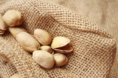 Pistachios nuts on a background of brownの写真素材