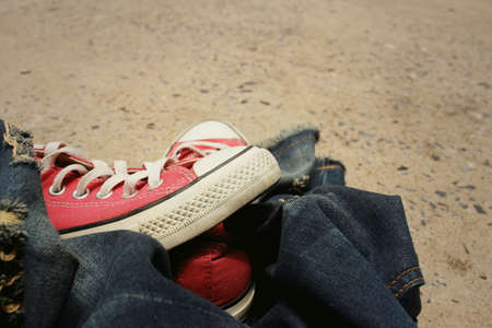 Red shoes with jeans on cement background.の写真素材