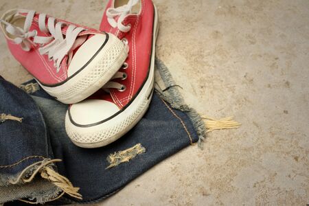 Red shoes with jeans on cement background.の写真素材