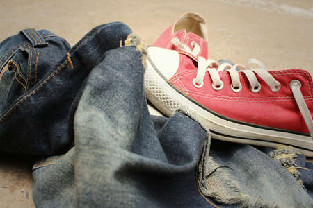 Red shoes with jeans on cement background.の写真素材