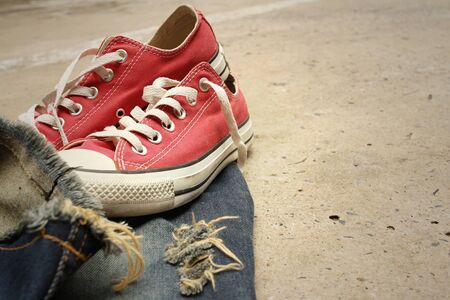 Red shoes with jeans on cement background.の写真素材