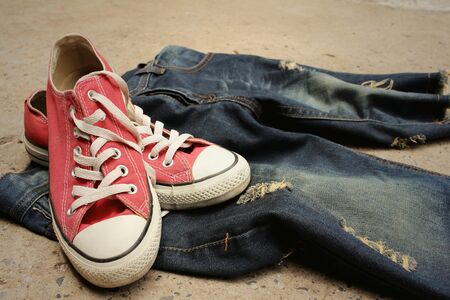Red shoes with jeans on cement background.の写真素材