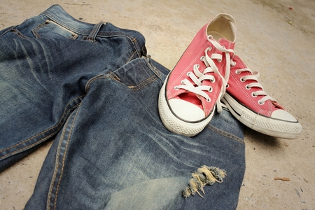 Red shoes with jeans on cement background.の写真素材