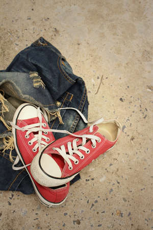 Red shoes with jeans on cement background.の写真素材