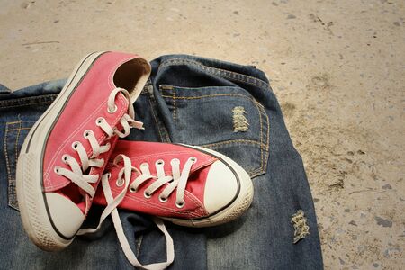 Red shoes with jeans on cement background.の写真素材