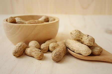 Peanut on background of a brown wood.
