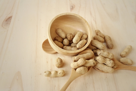 Peanut on background of a brown wood.