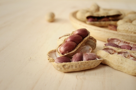 Peanut on background of a brown wood.