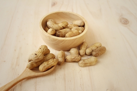 Peanut on background of a brown wood.
