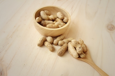 Peanut on background of a brown wood.