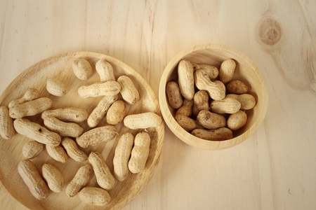 Peanut on background of a brown wood.