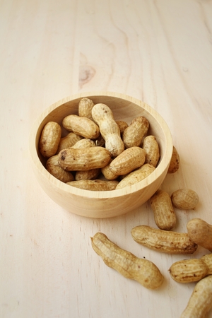 Peanut on background of a brown wood.