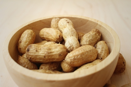 Peanut on background of a brown wood.