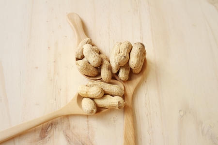 Peanut on background of a brown wood.