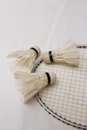 Shuttlecock and badminton racket on white background.の写真素材