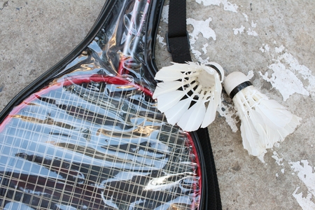 Shuttlecock and badminton racket on cement background.の写真素材