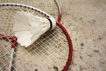 Shuttlecock and badminton racket on cement background.の写真素材