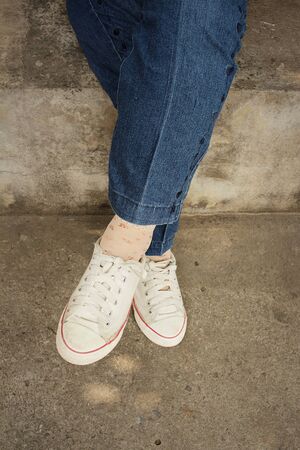 White shoes with  jeans sitting at the parkの写真素材