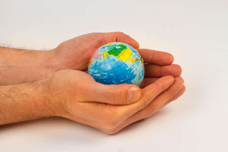 Man holding an earth globe in his handsの写真素材