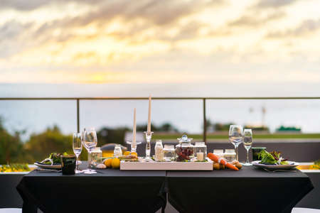 Empty glasses set in restaurant Dinner table outdoors at sunsetの写真素材