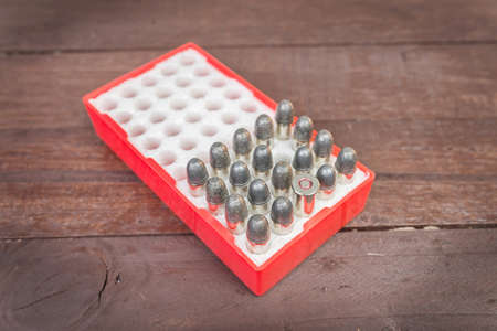 Red box of ammunition on wooden background