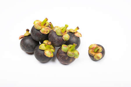 Mangosteen and cross section showing the thick purple skin and white flesh of the queen of friuts.の写真素材