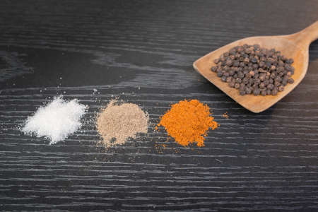 assorted spices and condiments on table black woodenの写真素材