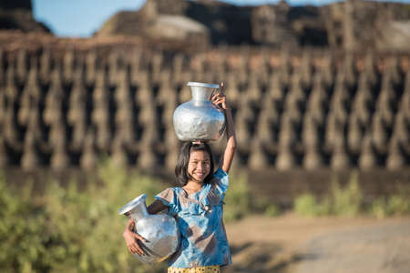 Mrauk U, MYANMAR - DEC 15, 2014: happy asian traditional harvest at myanmar, Mrauk-U carrying pots back home at Mrauk U on December 15, 2014 in Mrauk U, Myanmar.のeditorial素材