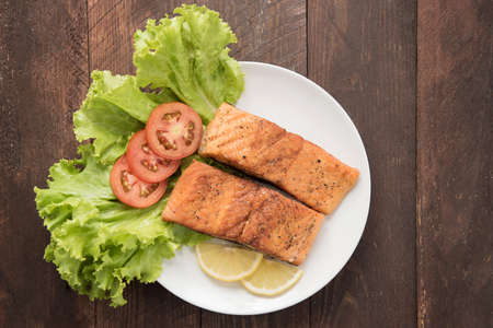 Grilled salmon fillet cooked BBQ and served with fresh herbs and lemon.の写真素材