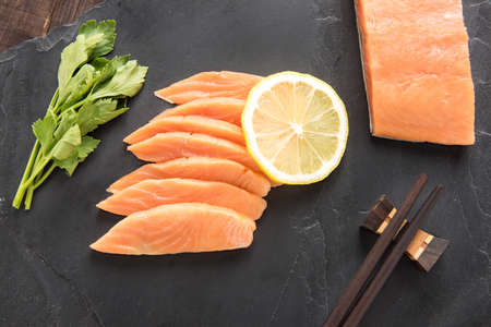 Top view fresh salmon with lemon on black backgroundの写真素材