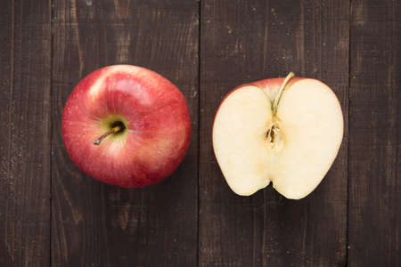Top view half fresh ripe red apples on wooden background.の写真素材