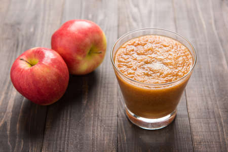 Flash red apples smoothie on Wooden background.の写真素材