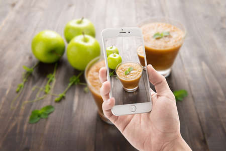 Taking photo of green apples smoothie on Wooden background.の写真素材