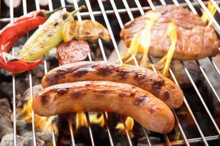 Sausage pork and chop steak on a flaming BBQ grillの写真素材